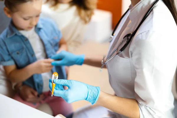 Médico caucásico manteniendo termómetro en brazo en clínica acogedora — Foto de Stock