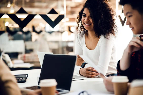 Vrolijke jonge vrouw werkt met collega 's in het kantoor — Stockfoto