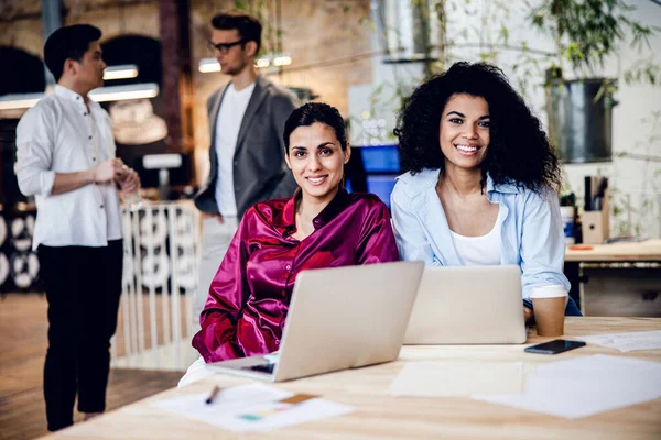 Jovens mulheres encantadoras usando laptop no trabalho — Fotografia de Stock