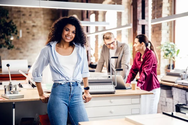 Une jeune femme séduisante passe du temps au bureau avec ses collègues — Photo