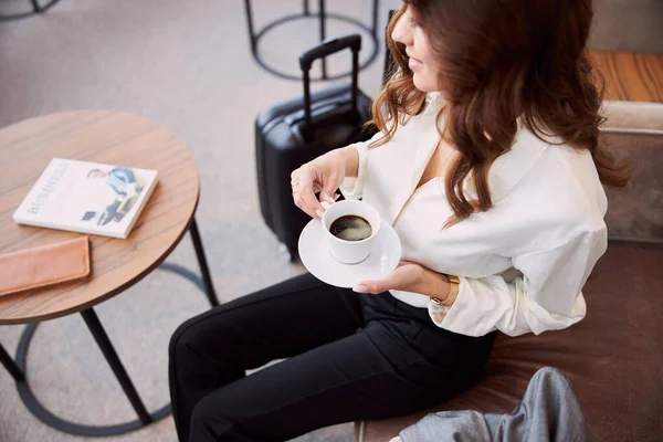 Elegante dama bebiendo café en la sala de espera del aeropuerto — Foto de Stock