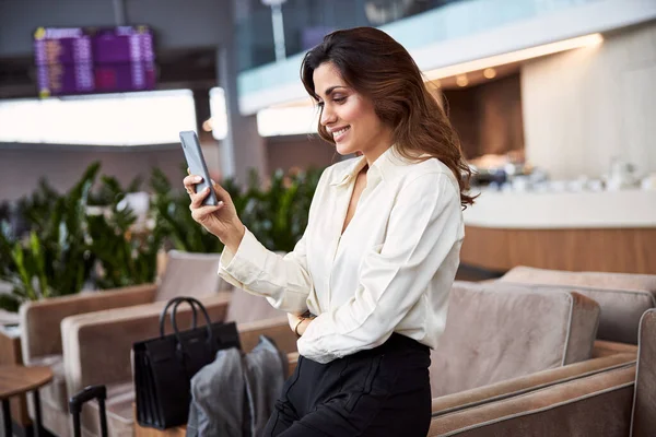 ビジネスセンターで携帯電話を使用してかなり女性を笑顔 — ストック写真