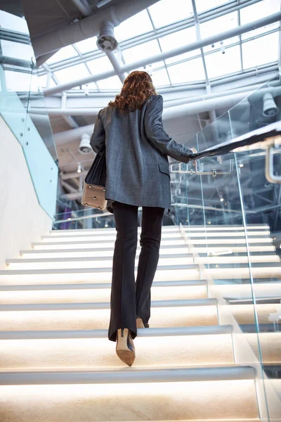 Elegante signora salire le scale nel business center — Foto Stock