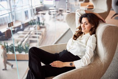 İş merkezinde sandalyede oturan hoş bir bayan.