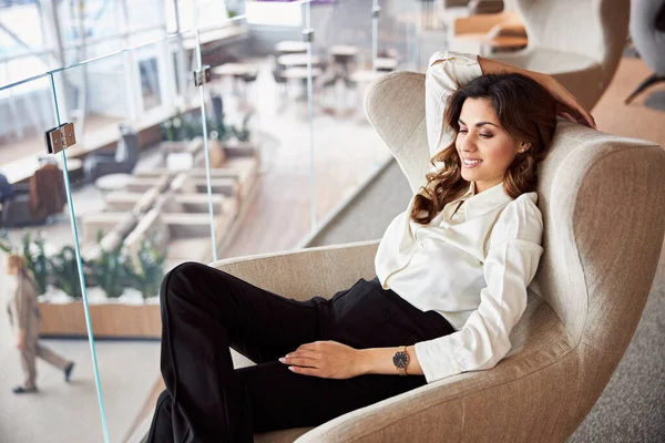 Charmante Dame sitzt im Stuhl im Business Center — Stockfoto