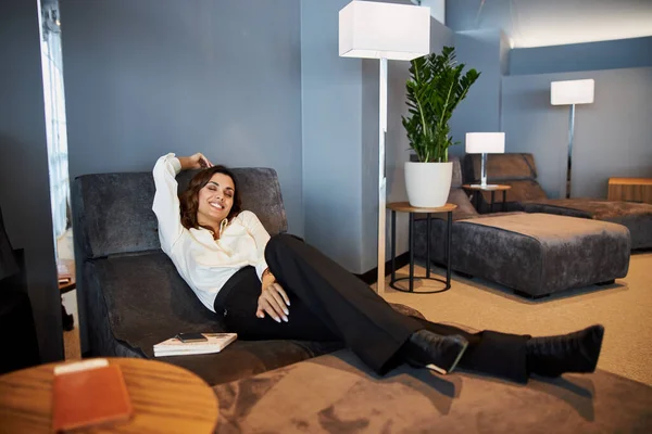 Fröhliche junge Frau entspannt sich in Lounge-Zone — Stockfoto