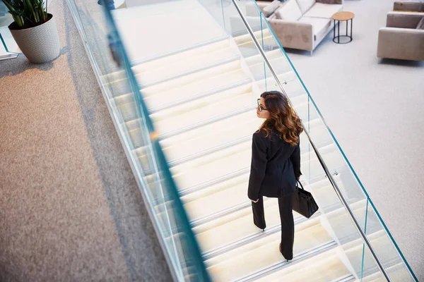 Stylish young woman climbing stairs in business center — Stock Photo, Image