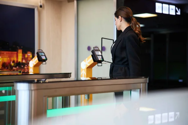 Mulher bonita em pé por leitor de cartão no aeroporto — Fotografia de Stock