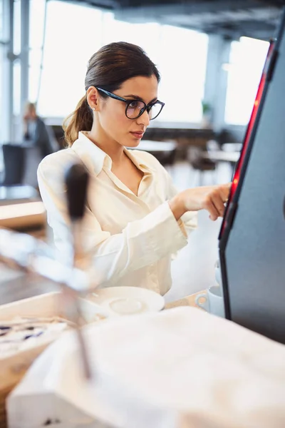 Affascinante giovane donna che utilizza macchina da caffè automatica — Foto Stock