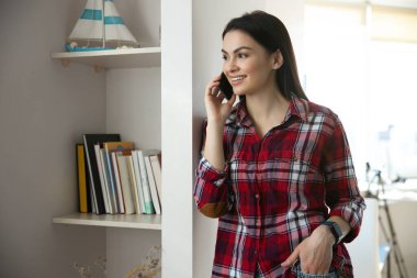 Neşeli kadın evde telefon konuşmasının keyfini çıkarıyor.