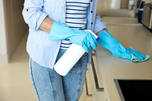 Ama de casa limpiando muebles en la cocina con desinfectante — Foto de Stock