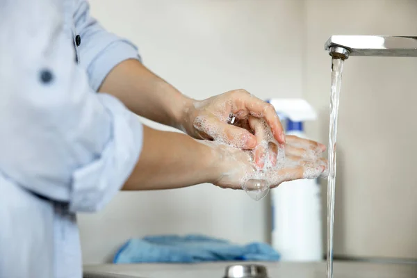 Femme soigneusement nettoyer les mains sous le robinet à la maison — Photo