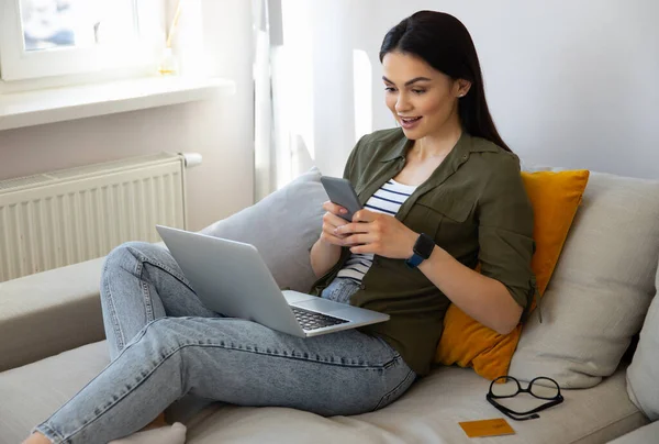 Amazed pretty lady using smartphone at home — Stock Photo, Image