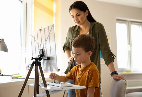 Lindo niño pintando cuadro y pasar tiempo con la madre —  Fotos de Stock