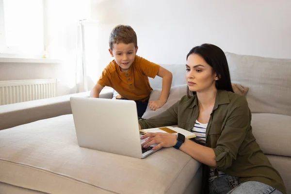Sevgi dolu anne, oğlunun online ödevlerini yapmasına yardım ediyor. — Stok fotoğraf