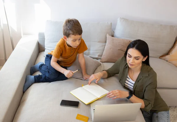 Güzel genç bir kadın oğlunun online ödevlerini yapmasına yardım ediyor. — Stok fotoğraf