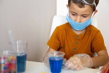Ciddi esmer çocuk oyun sırasında kimyasal deney yapıyor.