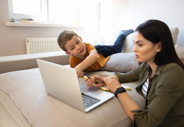 Evde dizüstü bilgisayar kullanan sevimli bir çocuk ve annesi. — Stok fotoğraf