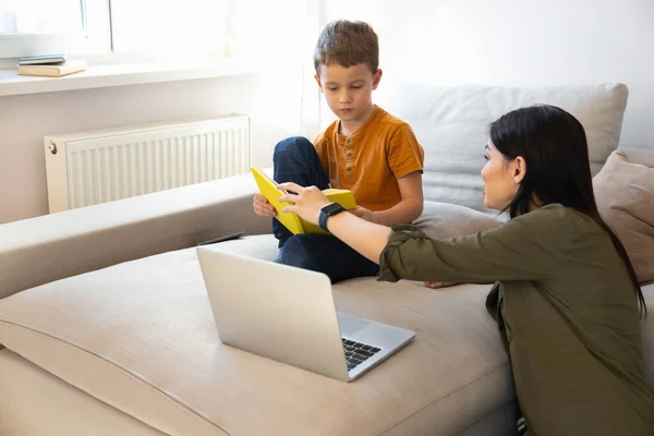 Mãe amorosa ajudando filho a estudar em casa — Fotografia de Stock