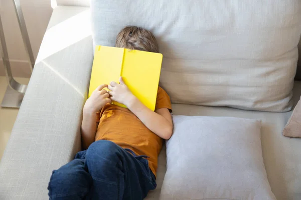 Gyermek elrejti arcát mögött a sárga notebook stock fotó — Stock Fotó