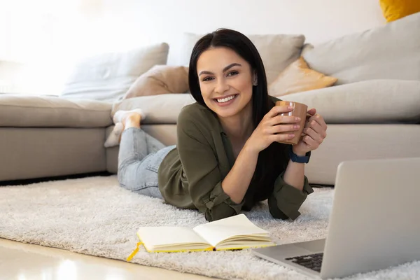 Vidám hölgy teát iszik, és élvezi az online munkát otthon — Stock Fotó
