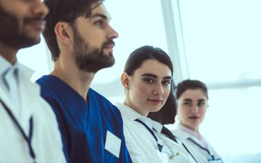 Çekici bayan doktor iş arkadaşlarıyla iş görüşmesi yapıyor.