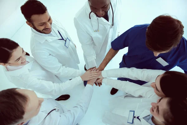 Equipe médica alegre juntando as mãos como símbolo de unidade — Fotografia de Stock