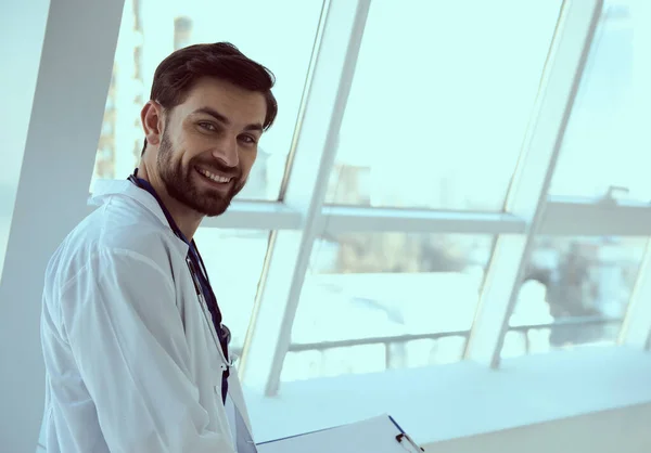 Alegre trabajador médico de pie junto a la ventana en el hospital — Foto de Stock