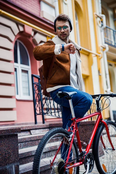 Rustige man op zoek naar het horloge voor het rijden op de fiets — Stockfoto