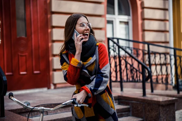 Dame excitée avec smartphone et vélo dans la rue — Photo