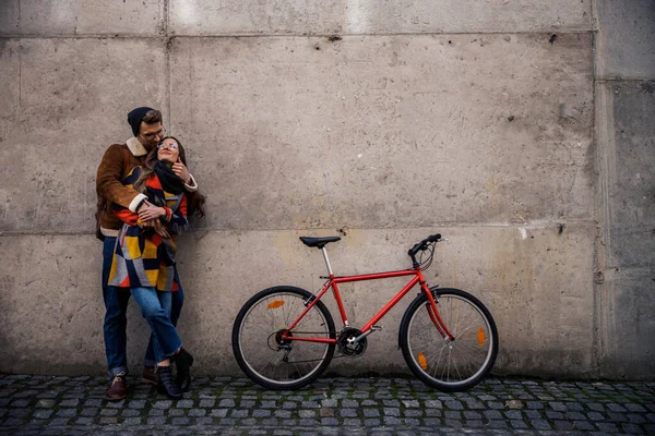 Beautiful romantic couple near the wall standing and hugging — Stock Photo, Image