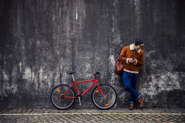 Rustige man met fiets en smartphone op zoek naar beneden stock foto — Stockfoto