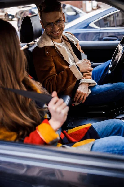 Mujer abrochándose el cinturón de seguridad y el conductor sonriéndole — Foto de Stock