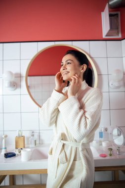 Banyo fotoğrafı çektikten sonra gülümseyen kadın.