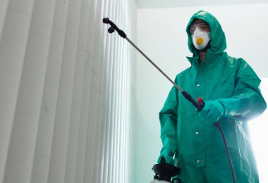 Ofisteki stok fotoğrafını sterilize ederek Coronavirus 'la savaşan uzman.