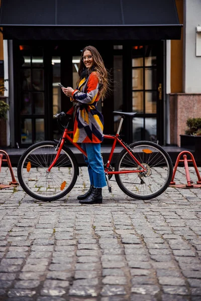 Θαύμα κυρία μπροστά από την είσοδο του ξενοδοχείου με ποδήλατο και gadget — Φωτογραφία Αρχείου