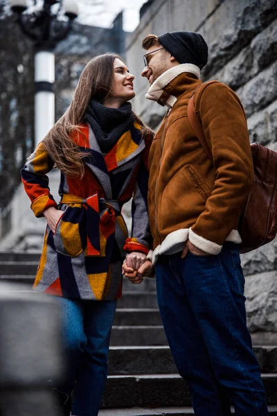 Cute couple on the stairs holding hands and looking romantic — Stock Photo, Image