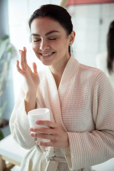 Mulher sorridente usando creme facial foto stock — Fotografia de Stock