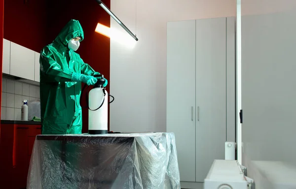Homme en combinaison de protection se préparant à travailler avec des produits chimiques pour la désinfection — Photo