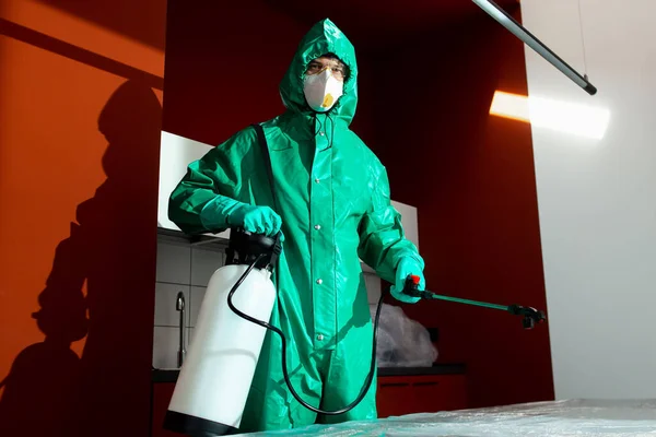 Homme portant réservoir d'eau de Javel tout en désinfectant la cuisine photo de stock — Photo