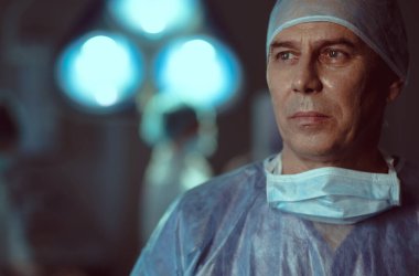 Ameliyatta yorucu bir günün ardından yorgun bir adam.