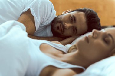 Yakışıklı bir adam karısının yanında uyanıyor.