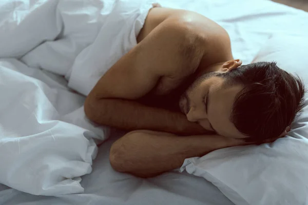 Nudo giovane uomo dormire su lino bianco — Foto Stock