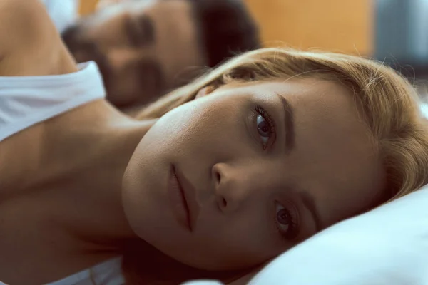 Mujer tranquila despertar en la cama cerca de novio — Foto de Stock