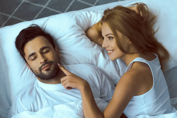 Lächelnde Frau weckt geliebten Mann am Morgen — Stockfoto