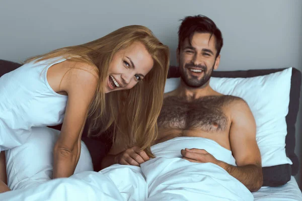 Jolly unga älskare som har roligt i sovrummet — Stockfoto