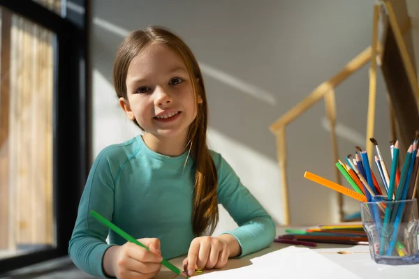 Menina alegre desenho com lápis de cor em casa — Fotografia de Stock