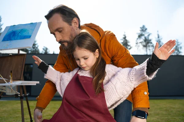 Padre amoroso ayudando a su hija a ponerse el delantal —  Fotos de Stock