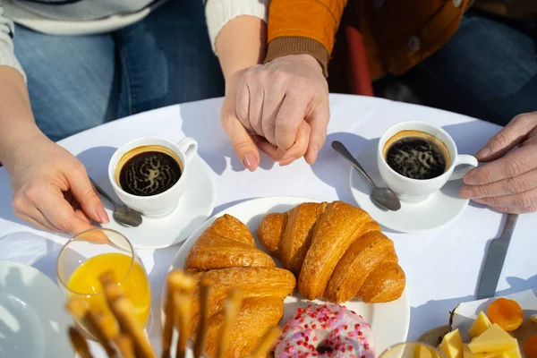 Ehepaar hält Händchen beim Frühstück im Freien — Stockfoto