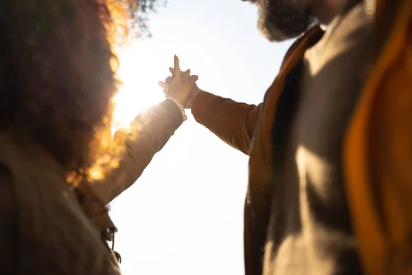 Любящие муж и жена держатся за руки под ярким небом — стоковое фото